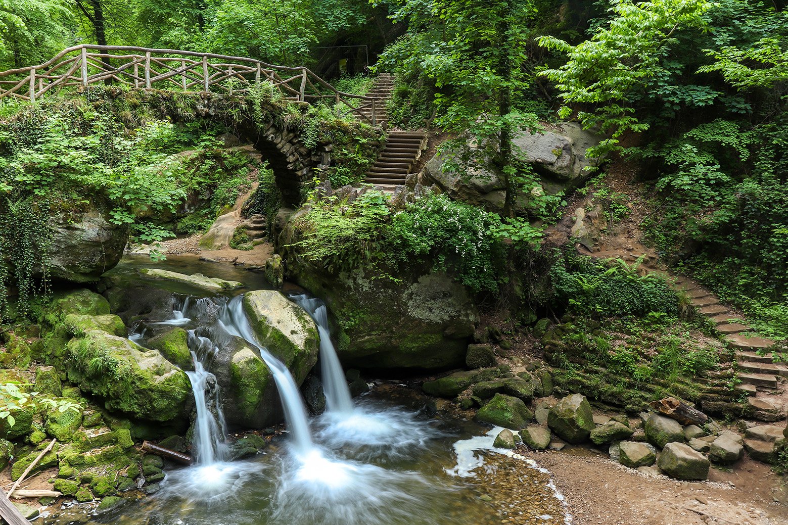 schiessentumpel Cascade, a waterfall and bridge from above on a spring day in uxembourg.